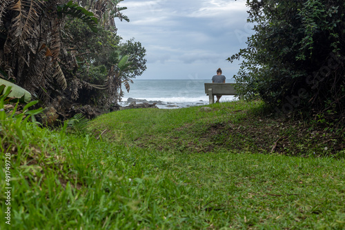 woman alone on a beanch with ocean and moody sky photo