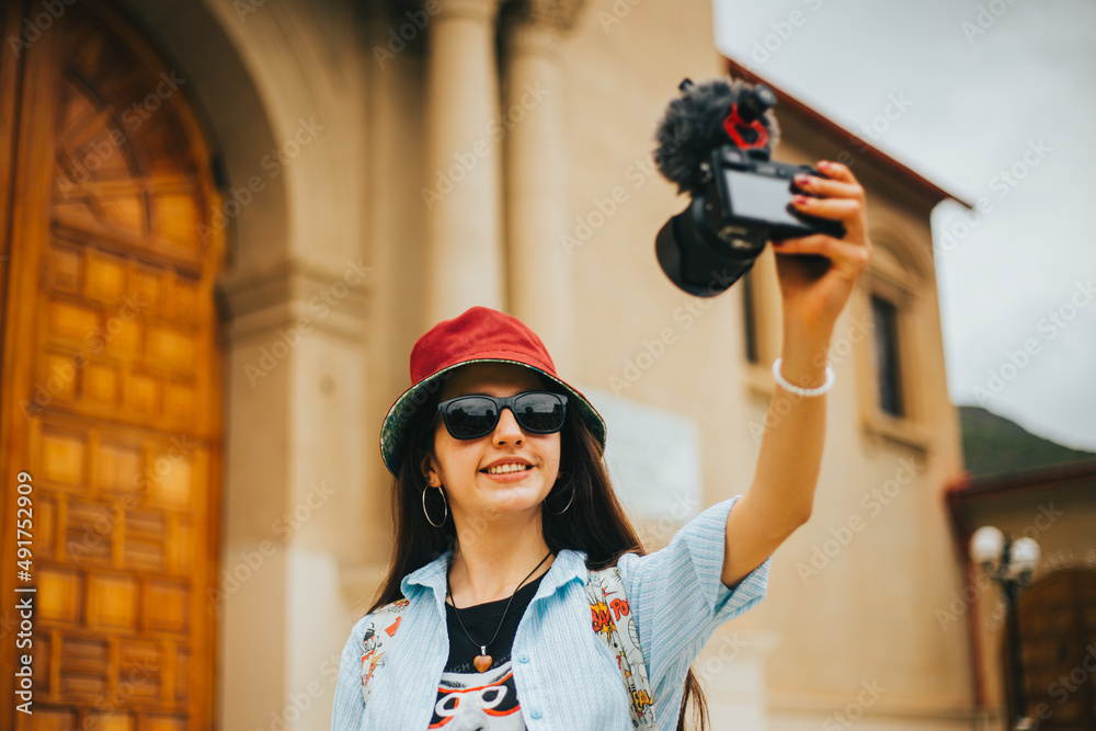 Mujer turista blogueando a fuera de una catedral Mujer turista blogueando a fuera de una catedral