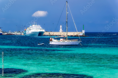 Yachts anchored at turquoise lagoon during summer day at island of Formentera, Spain.