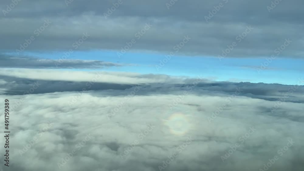 Cockpit view flying between layers of clouds with the hallo of the plane in front, daylight Cockpit view flying between layers of clouds with the hallo of the plane in front, daylight