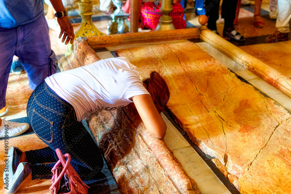 Christian pilgrims at The Stone of Anointing, where Jesus' body is said to have been anointed before burial in Jerusalem, Israel.