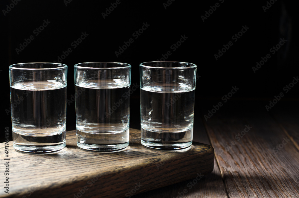 Glasses with Russian vodka on a brown wooden background. Copy space Glasses with Russian vodka on a brown wooden background. Copy space