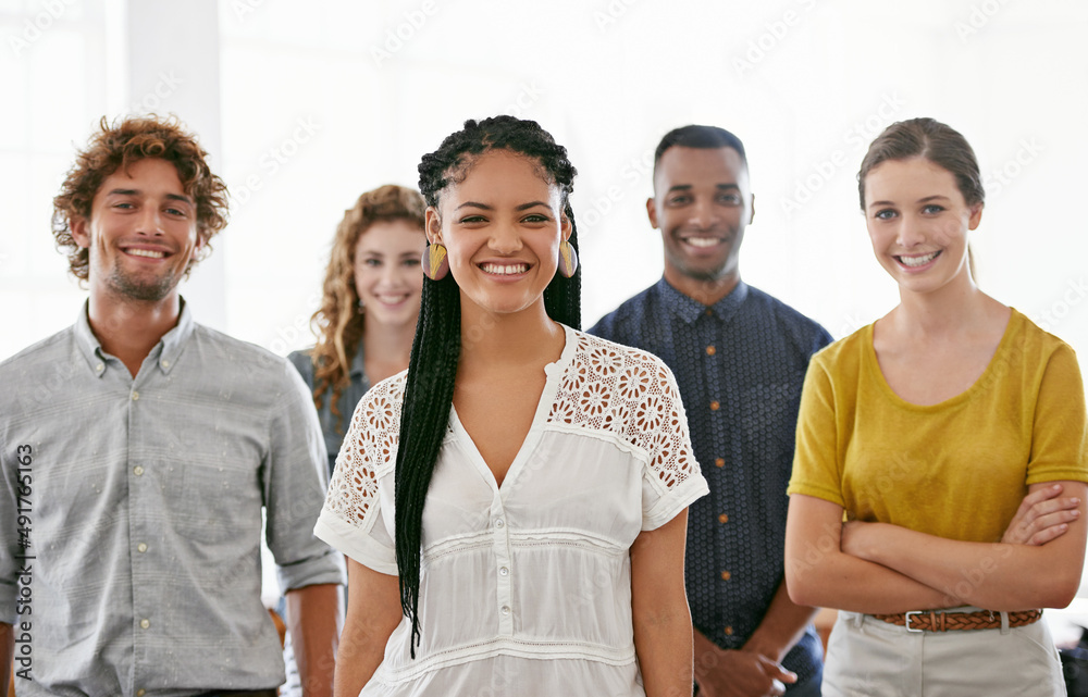 © Nicola Katie/peopleimages.com - Theyre a dedicated team. Cropped portrait of a diverse group of young colleagues standing in a brightly lit office.