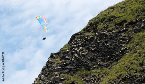 Vik, Iceland on july 30, 2021: Tandem paragliders flying through the air near Vik photo