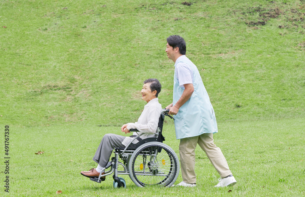 車椅子に乗った高齢者と介護士 屋外 車椅子に乗った高齢者と介護士 屋外