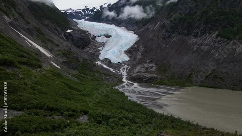 Bear Glacier cascading down a rugged mountain into Strohn Lake in Bear Glacier Provincial Park, British Columbia, Canada. Wide angle aerial shot photo