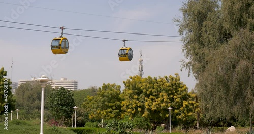 cable var in modern city cable car cabins moving over trees and city
