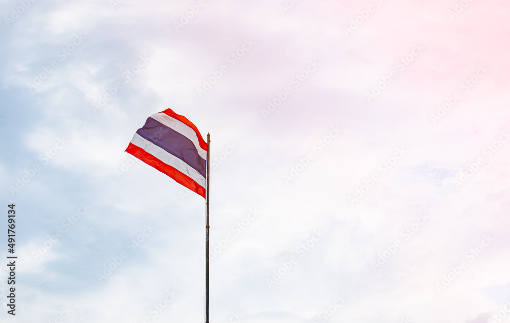 The Thai flag was blown by the wind, fluttering on the pole. get the sun be proud of the Thai people in an independent country The flag consists of red, blue and white.