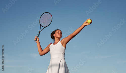 Black sportswoman playing tennis against blue sky © kegfire