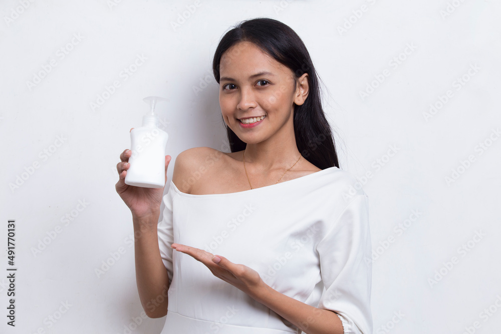 young beautiful asian woman putting skincare product to her face isolated on white background
young beautiful asian woman putting skincare product to her face isolated on white background