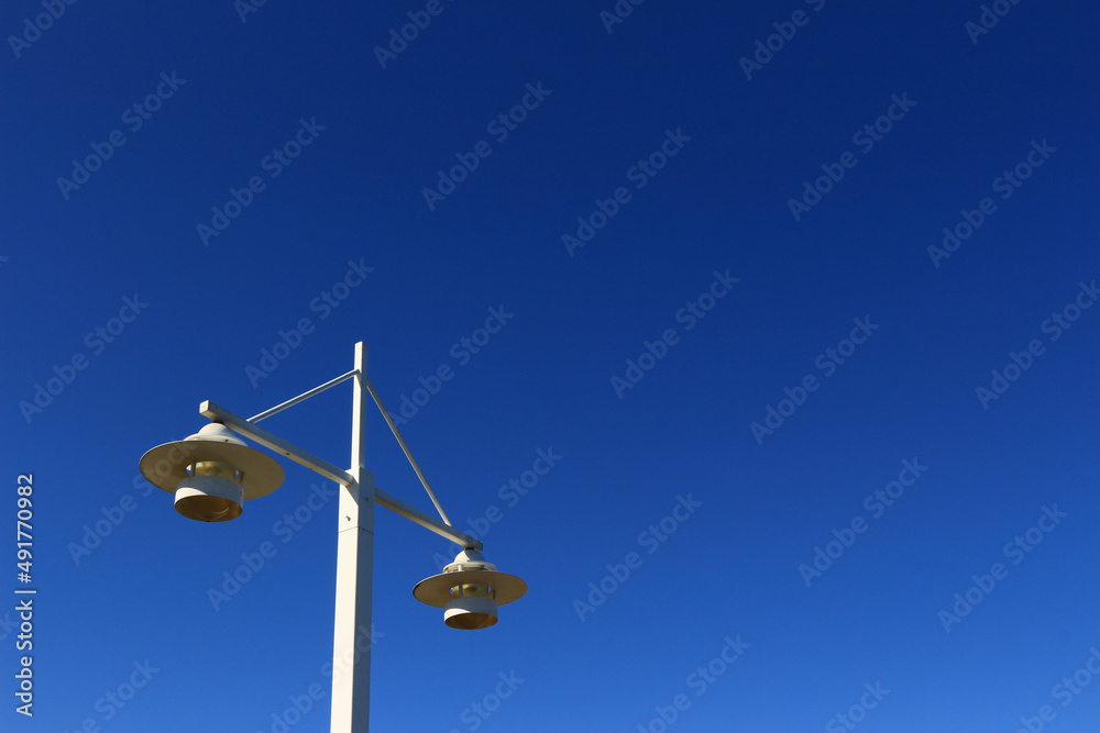 White streetlights and clear blue sky in a town by the sea White streetlights and clear blue sky in a town by the sea