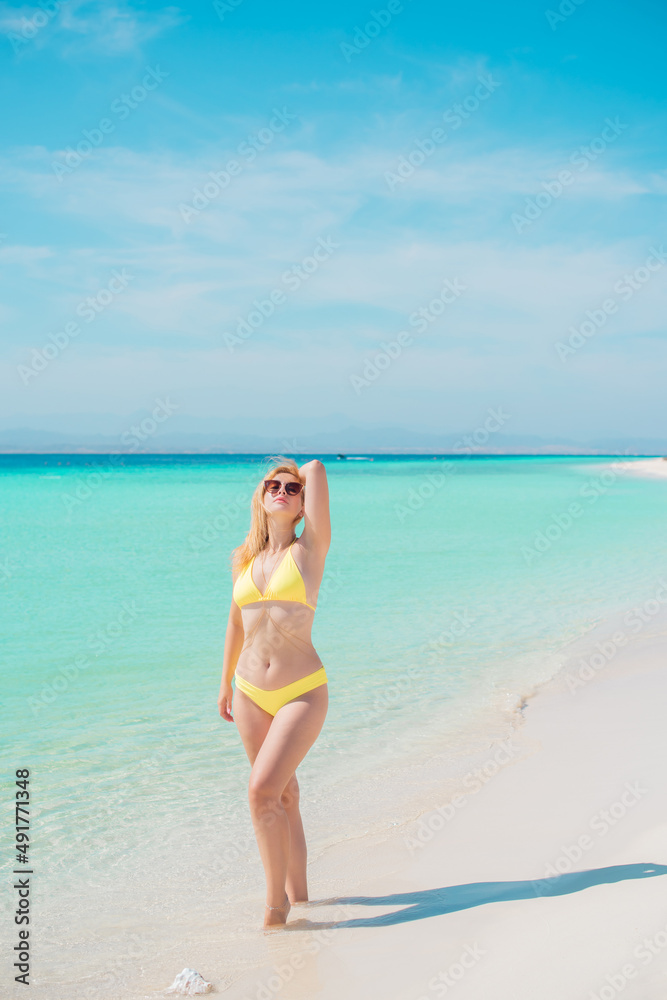 Ukrainian woman in yellow swimsuit in vacation, behind blue landscape, fashionable details