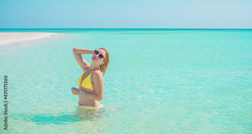 Ukrainian woman in yellow swimsuit in vacation, behind blue landscape, fashionable details