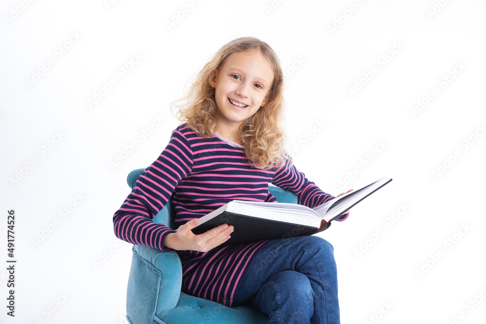 Young girl with blond hair enjoys learning and reading a book.