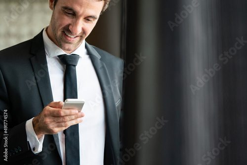 Young happy attractive business man using smartphone