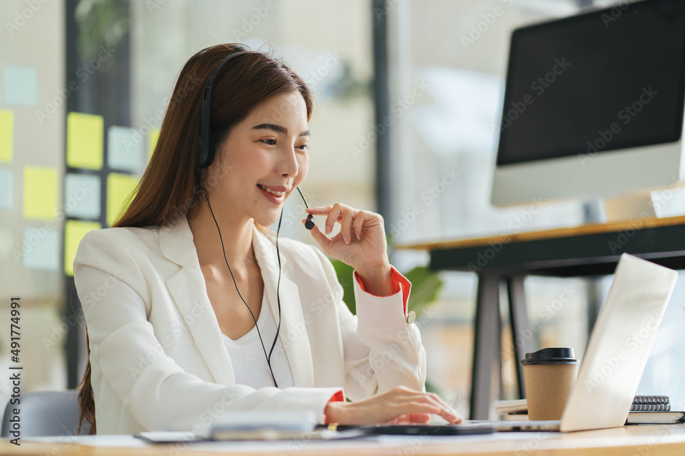 Call center agent with headset working on support hotline in modern office with copy space. Portrait of mature positive agent in conversation with customer over headset looking at camera. Call center agent with headset working on support hotline in modern office with copy space. Portrait of mature positive agent in conversation with customer over headset looking at camera.