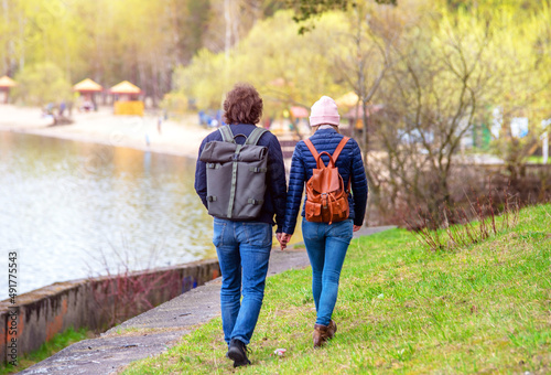 A guy and a girl walk along the path in the city Park 