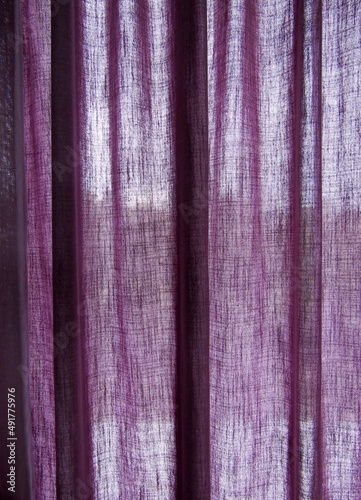 Purple curtain hanging on the rail. Modern material for interior decoration in living room.