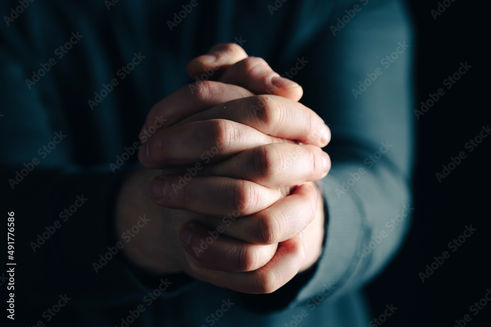 Man hands in praying position low key image