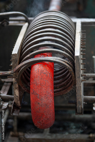 Induction, crucible melting furnace. A red-hot metal pipe takes the form of a half-branch under the influence of heat in an induction furnace photo