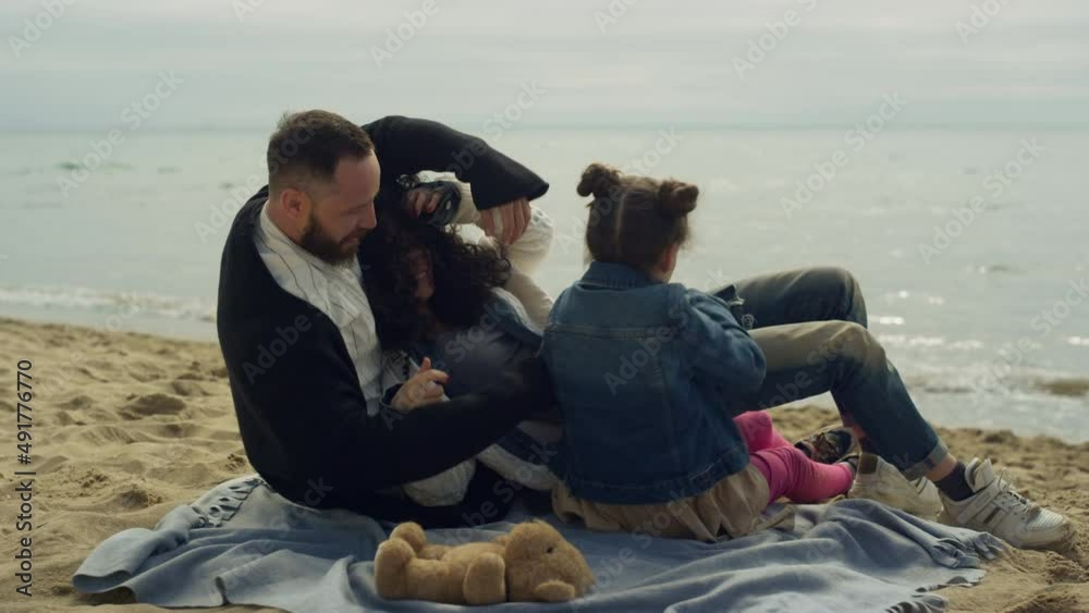 Joyful family group hugging on beach sand. Happy people cuddling by sea shore. Joyful family group hugging on beach sand. Happy people cuddling by sea shore.