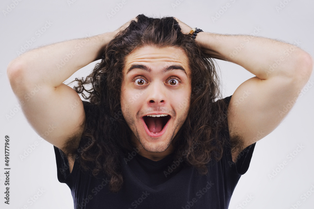 Mind. Blown. Studio portrait of a handsome young man looking surprised against a grey background. Mind. Blown. Studio portrait of a handsome young man looking surprised against a grey background.