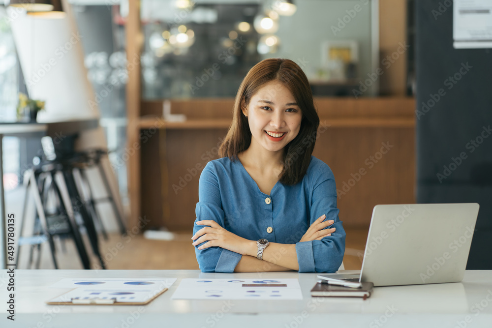 Attractive young brunette asian woman using laptop computer while sitting in a stylish living room. Attractive young brunette asian woman using laptop computer while sitting in a stylish living room.