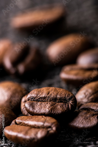 Some roasted coffee beans in the foreground with selective focus.