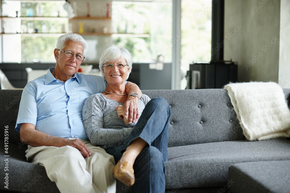 Love is just a word until someone gives it meaning. Portrait of a happy senior couple sitting in their living room. Love is just a word until someone gives it meaning. Portrait of a happy senior couple sitting in their living room.