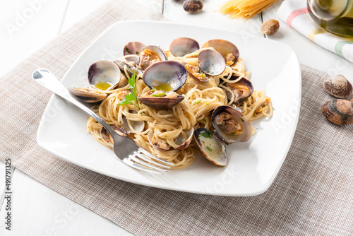 Piatto di deliziosi spaghetti con vongole veraci, olio, aglio e prezzemolo, tipica ricetta di pasta Italiana  photo
