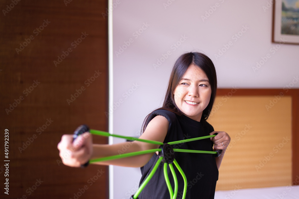 Woman doing exercises and stretching for treatment with a rubber resistance bands at home,Physical therapy concept Woman doing exercises and stretching for treatment with a rubber resistance bands at home,Physical therapy concept