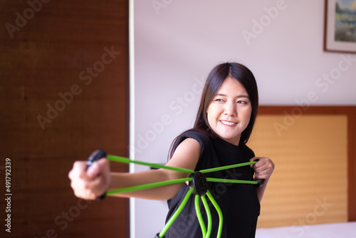 Woman doing exercises and stretching for treatment with a rubber resistance bands at home,Physical therapy concept