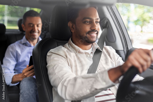 transportation, vehicle and people concept - happy smiling indian male driver driving car with passenger photo