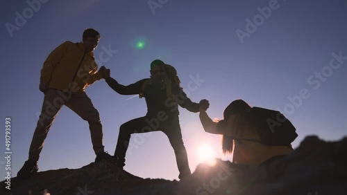 Family team success.Silhouette of group people.Climb to the top of mountain.Helping hand family victory.Teamwork concept.Business handshake.Helping hand of business people.Teamwork is path to success photo
