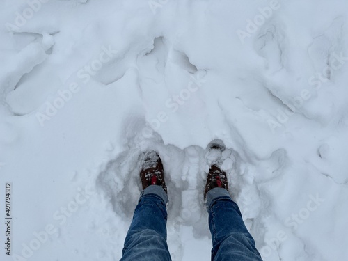 Boots in the deep snow. Walking through deep snowbank. Cold. Warm shoes. Deep. Wintertime. Snow. Snowdrift. Season. Winter. Denim trousers