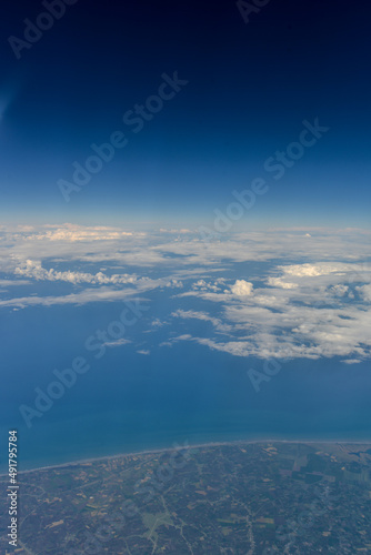 vue aérienne ligne côtière et nuage à l'horizon sur fond bleu 