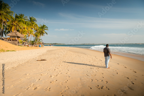 Magnifique plage vierge du sud du Sri Lanka au sable doré et homme de dos regardant l'océan Indien