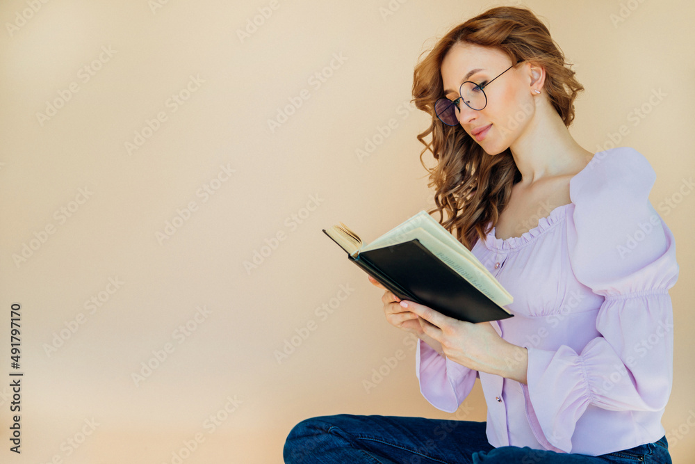 Portrait of a positive cheerful student holding a book. The teacher is preparing for the lesson. Portrait of a positive cheerful student holding a book. The teacher is preparing for the lesson.