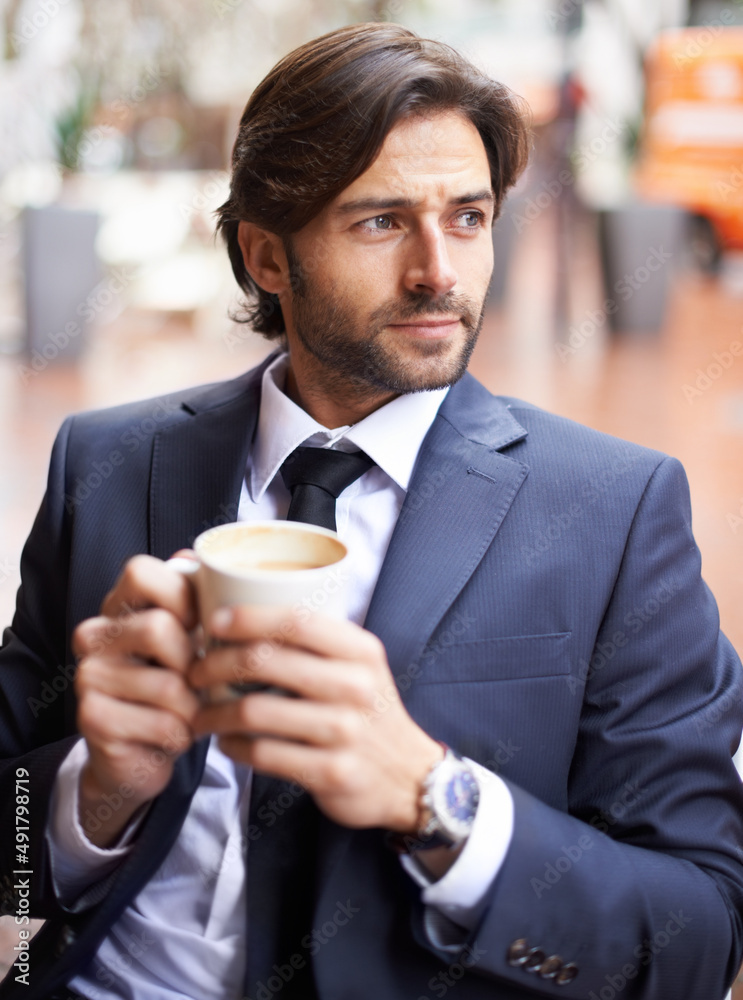 Sitting watching the world go by. A thoughtful businessman drinking coffee outdoors at a coffee shop. Sitting watching the world go by. A thoughtful businessman drinking coffee outdoors at a coffee shop.