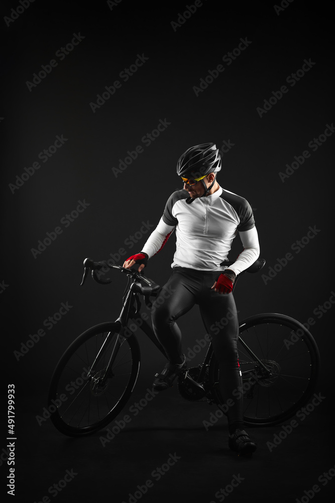 Fototapeta premium male cyclist with road bicycle on black background