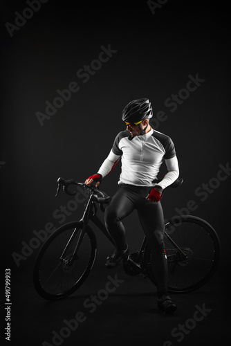 male cyclist with road bicycle on black background