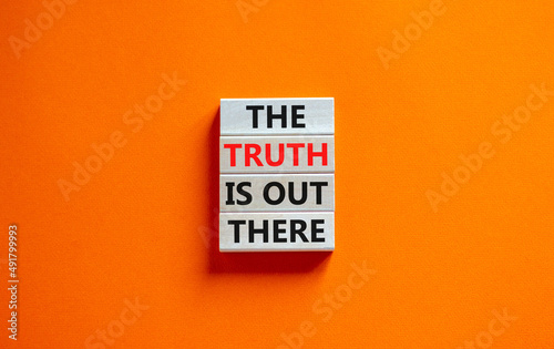 The truth is out there symbol. Concept words The truth is out there on wooden blocks. Beautiful orange table orange background. The truth is out there business concept. Copy space. photo