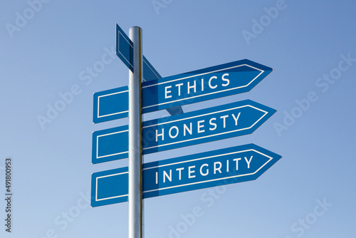 Ethics honesty integrity words on signpost isolated on sky background photo