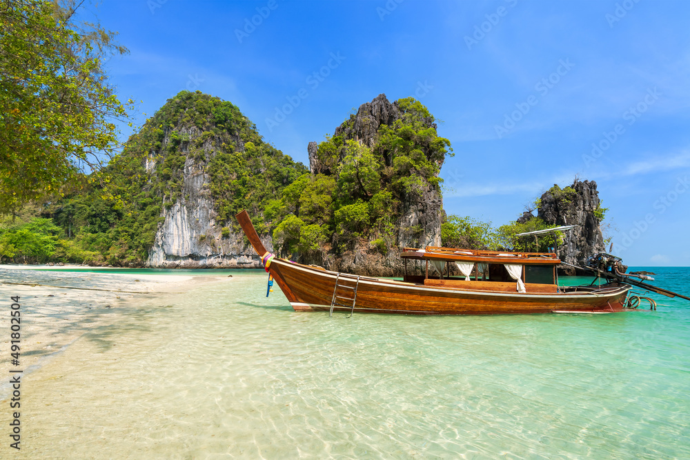 Ko Hong island and exotic beach with mountain cliff, with crystal clear water and white sand and boat Krabi, Thailand