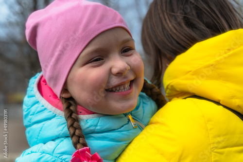 Portrait of a mother with her daughter outside. A five-year-old girl and a middle-aged woman. A happy family. Outside.