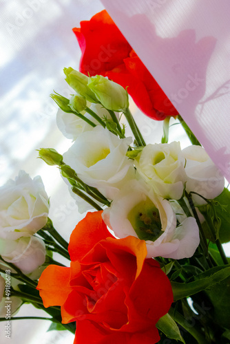 bouquet of white and orange spring roses on a soft pink background