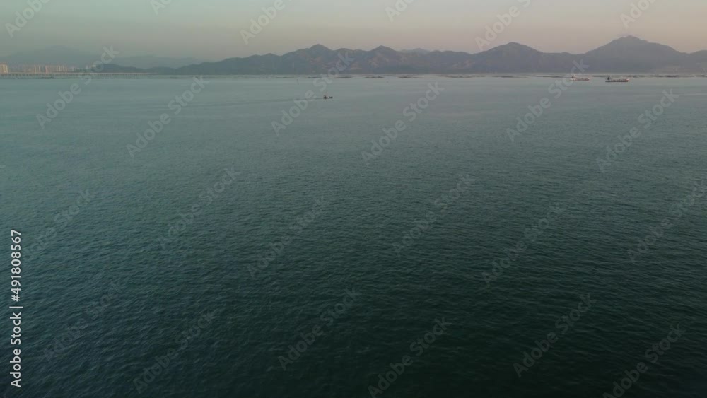 Sea air view. Several boats in the sea. Mountains on the background of the sea. White haze
