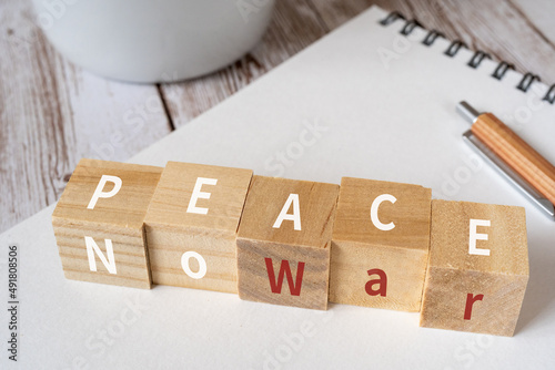 戦争と平和のイメージ｜「PEACE」「WAR」と書かれた積み木、ペン、ノート、コップ