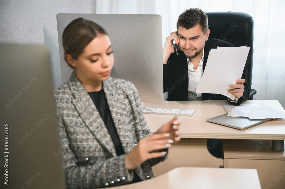 Young attractive woman and adult man are working in the office. Open space concept for teamwork Young attractive woman and adult man are working in the office. Open space concept for teamwork
