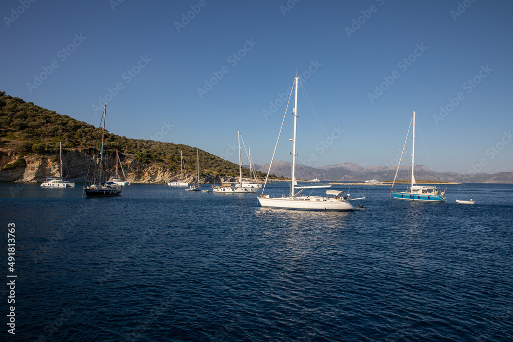 Anchored sailboats off the coast of the KASTOS island, Lefkada Regional unit, Ionian Islands, Greece in summer morning.